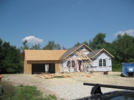 New construction of house with partial roof and no exterior coverage.