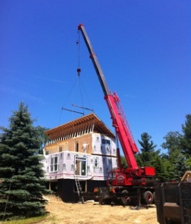 crane lifting roof on modular house photo